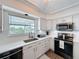 Bright kitchen features white cabinets, stainless steel appliances, and views from the sink window at 3344 Gardenia Dr, Hernando Beach, FL 34607