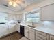 Bright kitchen features white cabinets and countertops, stainless steel sink, and wood-look floors at 3344 Gardenia Dr, Hernando Beach, FL 34607