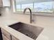 Close up on modern kitchen sink with white countertop, tiled backsplash, and a window view at 3344 Gardenia Dr, Hernando Beach, FL 34607