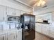 Open kitchen design featuring white cabinets, countertops, stainless steel appliances, and wood look floors at 3344 Gardenia Dr, Hernando Beach, FL 34607