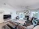 Bright living room boasts a cozy fireplace, ceiling fan and a large leather sectional sofa at 3344 Gardenia Dr, Hernando Beach, FL 34607