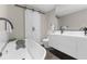 Modern bathroom featuring a soaking tub, a floating vanity, and a sliding barn door at 4144 Glade Rd, Spring Hill, FL 34606