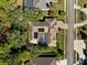 Overhead aerial view of home featuring a screen enclosed pool, a tile roof, and mature trees at 5383 Firethorn Pt, Spring Hill, FL 34609
