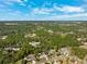 Expansive aerial view of the community showcasing lush landscapes and neighborhood homes, under a bright blue sky at 5383 Firethorn Pt, Spring Hill, FL 34609