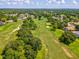 Aerial view of the golf course surrounded by residential homes and lush greenery at 5383 Firethorn Pt, Spring Hill, FL 34609