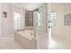 Bathroom with a soaking tub, glass block accents, and tile surround creates a luxurious and private space at 5383 Firethorn Pt, Spring Hill, FL 34609