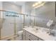 Bright bathroom featuring a glass-enclosed shower with gold trim and a white vanity with a large mirror at 5383 Firethorn Pt, Spring Hill, FL 34609
