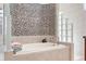 A spacious bathroom features custom tile detail and soaking tub at 5383 Firethorn Pt, Spring Hill, FL 34609