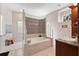 A luxurious bathroom with tile detail, soaking tub and glass block window at 5383 Firethorn Pt, Spring Hill, FL 34609