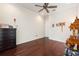 Bedroom with hardwood floors, a ceiling fan, and a door to the hallway at 5383 Firethorn Pt, Spring Hill, FL 34609