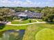 An aerial shot shows the well-maintained clubhouse and surrounding grounds, with lush greenery and a water feature at 5383 Firethorn Pt, Spring Hill, FL 34609