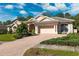 Gorgeous single-story home featuring a brick-paved driveway and beautiful landscaping at 5383 Firethorn Pt, Spring Hill, FL 34609