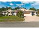 Charming single-story home boasting lush landscaping, an American flag, and a brick-paved driveway at 5383 Firethorn Pt, Spring Hill, FL 34609
