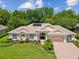Stunning single-story home featuring a tile roof, manicured landscaping, and an attached two-car garage at 5383 Firethorn Pt, Spring Hill, FL 34609