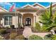 Close-up of the front entrance featuring double doors with decorative wreaths, columns, and an American flag at 5383 Firethorn Pt, Spring Hill, FL 34609