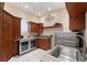Spacious laundry area with cherry wood cabinets, a granite counter, and a stainless-steel refrigerator at 5383 Firethorn Pt, Spring Hill, FL 34609