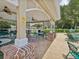 A covered outdoor lounge with seating and tables near the pool at 5383 Firethorn Pt, Spring Hill, FL 34609