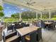 Covered outdoor seating area with tables, chairs, ceiling fans and views of the grounds at 5383 Firethorn Pt, Spring Hill, FL 34609