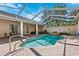 Beautiful pool and hot tub in a screened-in enclosure featuring brick-paved decking and backyard at 5383 Firethorn Pt, Spring Hill, FL 34609