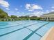 Spacious community pool area with ample seating, perfect for relaxation and recreation on a sunny day at 5383 Firethorn Pt, Spring Hill, FL 34609
