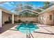 Swimming pool area with a screened enclosure, patio, and lush landscaping at 5383 Firethorn Pt, Spring Hill, FL 34609