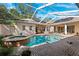 An inviting in-ground pool and spa are surrounded by a screened enclosure and brick pavers at 5383 Firethorn Pt, Spring Hill, FL 34609