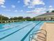Outdoor swimming pool with lap lanes, lounge chairs, and view of the clubhouse building at 5383 Firethorn Pt, Spring Hill, FL 34609