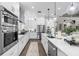 Modern kitchen featuring white cabinetry, stainless steel appliances, and elegant pendant lighting over the island at 5731 Summit View Dr, Brooksville, FL 34601