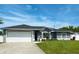 Charming single-story home boasts a well-manicured lawn, two-car garage, and sleek gray paint scheme at 5801 65Th N Ter, Pinellas Park, FL 33781