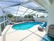 Inviting screened-in pool with blue lounge chairs and privacy fence at 5801 65Th N Ter, Pinellas Park, FL 33781