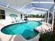 Inviting screened-in pool with a baja shelf and sun loungers for relaxation at 5801 65Th N Ter, Pinellas Park, FL 33781