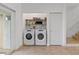 Functional laundry area with modern washer and dryer, shelving, and tile flooring at 6027 Bayside Key Dr, Tampa, FL 33615
