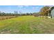 Sprawling backyard featuring a wooden fence, mature trees, and a level grassy area at 6413 Emerson Rd, Brooksville, FL 34601