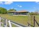 View of the back of the home with screened in patio and fenced in grass yard at 6413 Emerson Rd, Brooksville, FL 34601