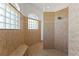 Modern bathroom features a tiled walk-in shower, a glass block window, and a built-in bench at 6413 Emerson Rd, Brooksville, FL 34601