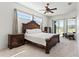 Bright main bedroom with tray ceilings, neutral carpet, and patio access at 6413 Emerson Rd, Brooksville, FL 34601