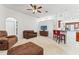 Living room featuring neutral carpet, ceiling fan, sofa, and kitchen bar with red stools at 6413 Emerson Rd, Brooksville, FL 34601