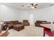Open living room with neutral carpet, ceiling fan and comfortable brown sofas and ottoman at 6413 Emerson Rd, Brooksville, FL 34601