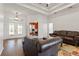 Spacious living room featuring tray ceilings, hardwood floors, and view into office space at 6413 Emerson Rd, Brooksville, FL 34601
