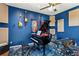 This music room features an upright piano, sound proofing, guitars, wood flooring, and natural light at 6413 Emerson Rd, Brooksville, FL 34601