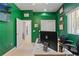 Green home office with modern white desk and dual door access, offering a workspace at 6413 Emerson Rd, Brooksville, FL 34601