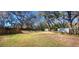 Large private backyard with mature trees and two storage sheds at 6825 Main St, New Port Richey, FL 34653