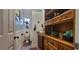 Hall bathroom featuring wood vanity, wood floors, toilet and a stained-glass window at 6825 Main St, New Port Richey, FL 34653