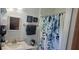 Bathroom with a floral shower curtain, a framed mirror, and decorative accents creating a relaxing atmosphere at 6825 Main St, New Port Richey, FL 34653