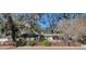 Charming single-story home with a welcoming front porch and a well-maintained yard and a brown picket fence at 6825 Main St, New Port Richey, FL 34653