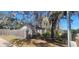 Exterior shot showing the side of the house behind a wooden fence and lush trees at 6825 Main St, New Port Richey, FL 34653