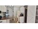 Kitchen space with island, white cabinets, white appliances and barn doors at 6825 Main St, New Port Richey, FL 34653