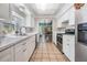 Bright kitchen with white cabinets, stainless steel appliances, and tile flooring at 7065 Red Oak Loop, New Port Richey, FL 34654