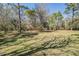 Picturesque backyard with mature trees and lush green grass, perfect for outdoor activities at 7065 Red Oak Loop, New Port Richey, FL 34654