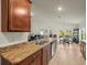 Well-lit kitchen featuring granite countertops, stainless steel appliances, and open layout to dining area at 7105 Wirevine Dr, Brooksville, FL 34602